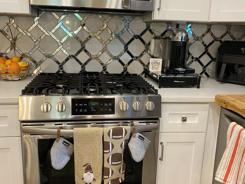 Polished stainless-steel range and microwave with a wiped-down tile backsplash after a kitchen cleaning in Greater New Orleans
