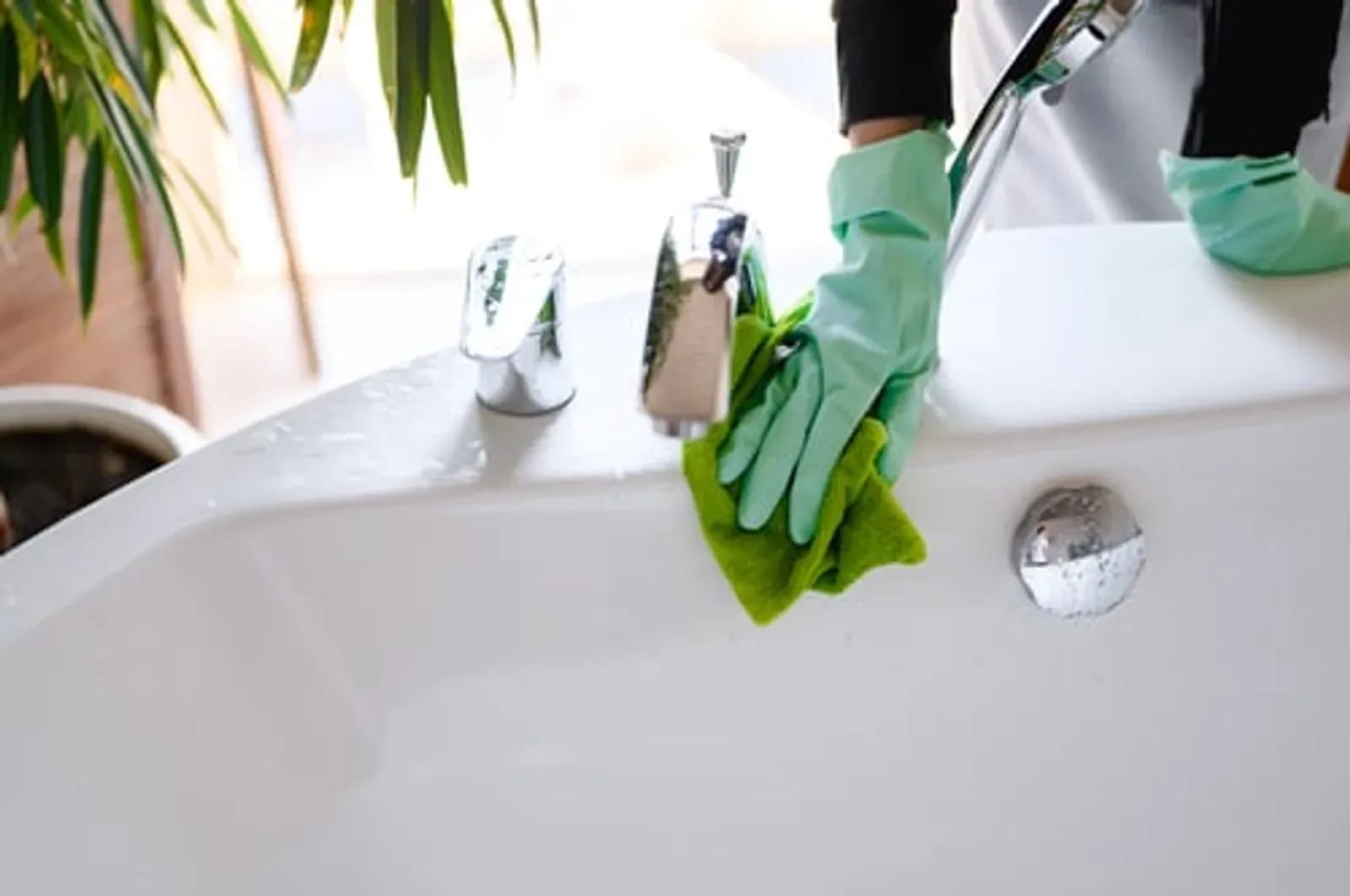 Enma Cleaning professional wiping down a bathroom sink during a regular house cleaning in Kenner, LA